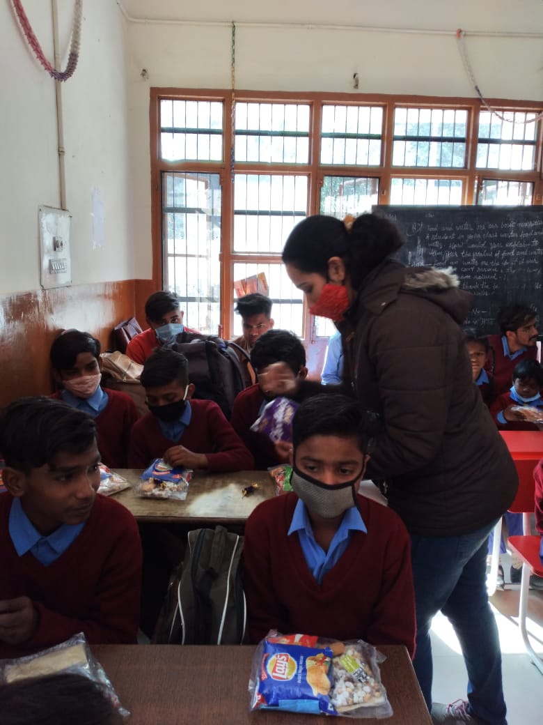 Venerate welfare Foundation's Volunteer handover the snacks to kids